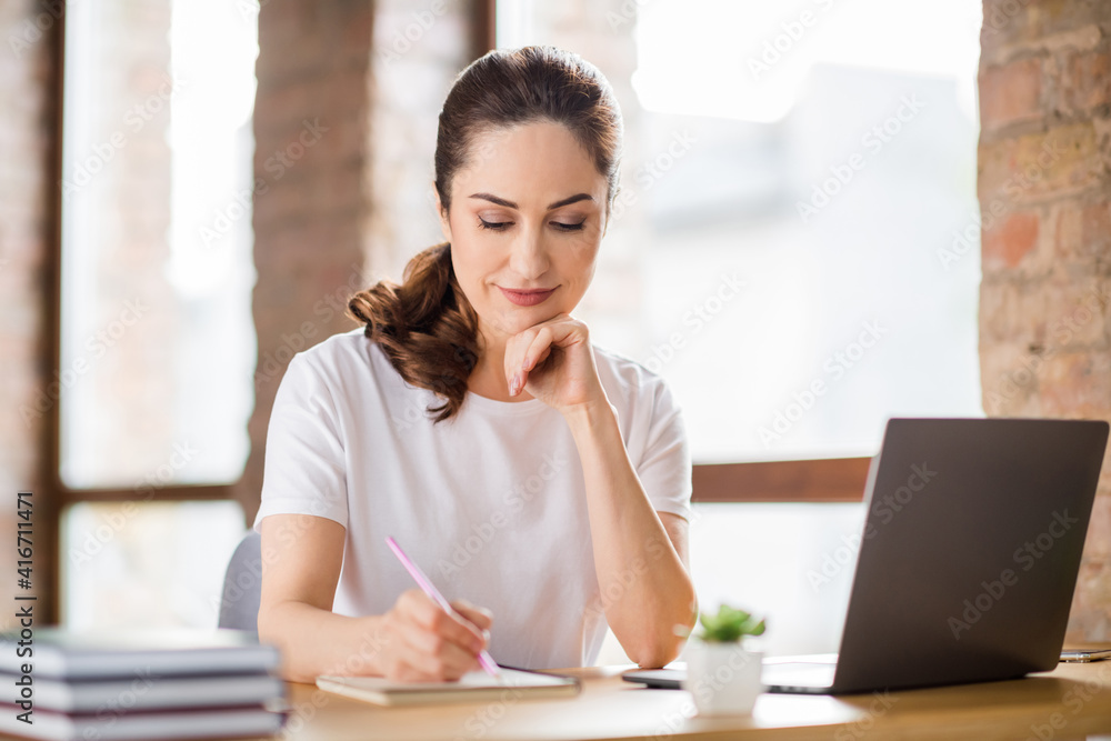 Photo of charming lady arm under chin hold pen writing notes have good mood working from home indoors