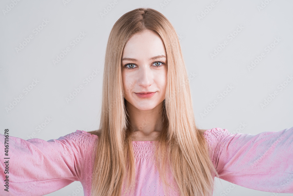 Fototapeta premium Portrait of young blonde woman with hug gesture in studio on white background