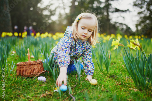 Cuadro en lienzo Three year old girl playing egg hunt on Easter