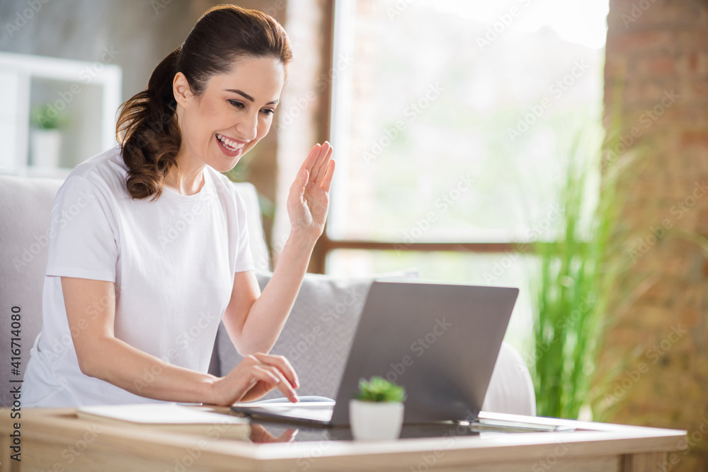 Photo of young happy smiling positive businesswoman having video call working in laptop remotely at home house Photo of young happy smiling positive businesswoman having video call working in laptop remotely at home house
