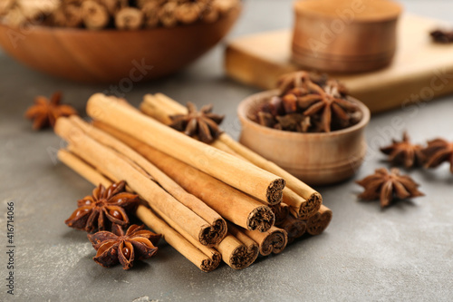 Aromatic cinnamon sticks and anise on grey table
