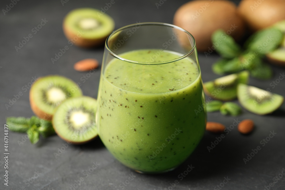 Delicious kiwi smoothie and fresh fruits on grey table Delicious kiwi smoothie and fresh fruits on grey table