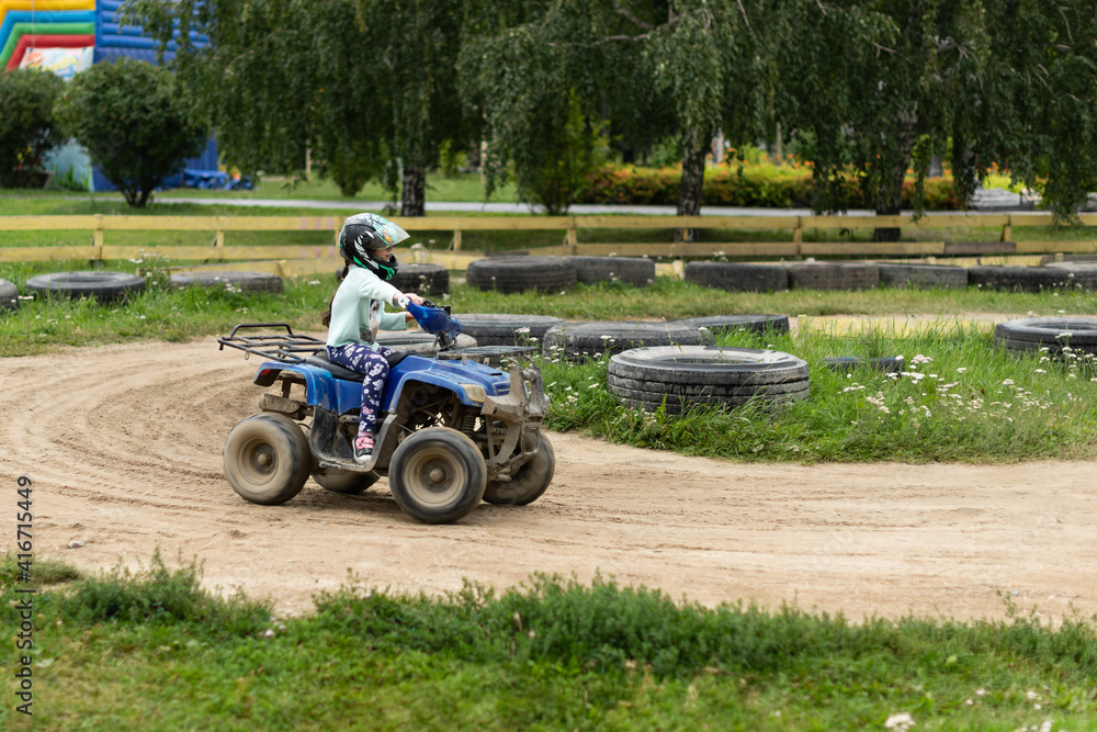 a child rides an ATV on the track a child rides an ATV on the track