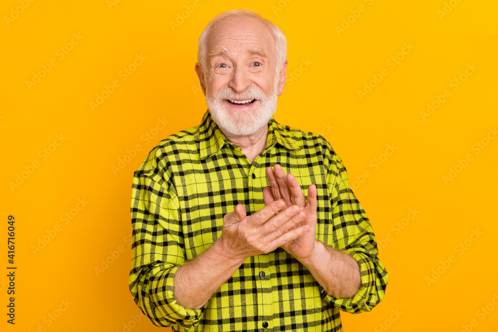 Photo of cheerful man happy positive smile applause congrats pensioner grandfather isolated over yellow color background Photo of cheerful man happy positive smile applause congrats pensioner grandfather isolated over yellow color background