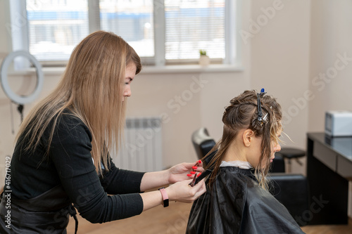 female hairdresser cutting hair of young woman