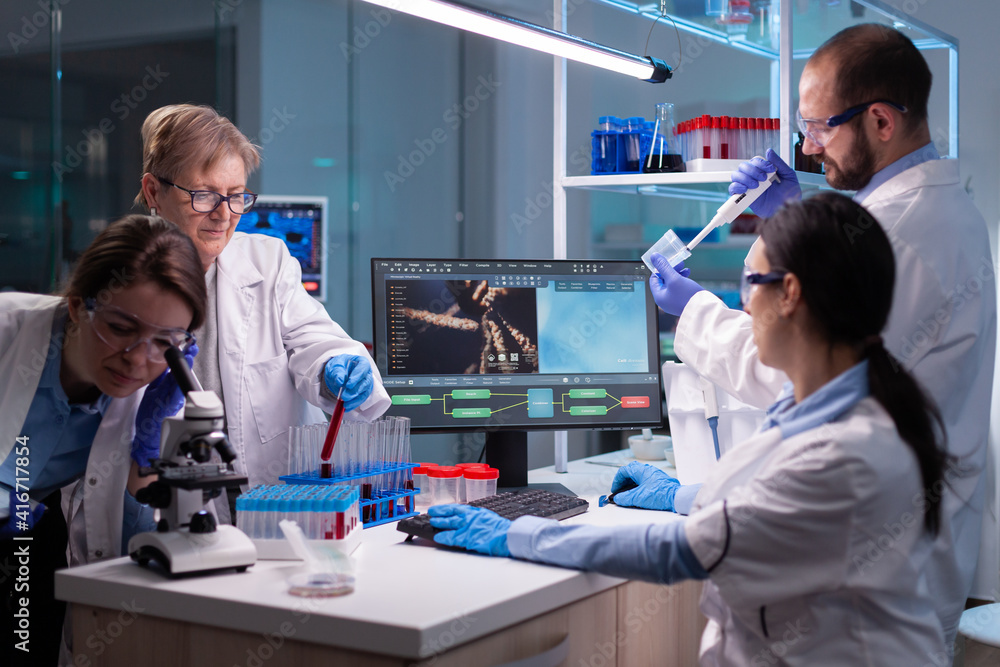 Fototapeta premium Team of scientific investigation examining resultes of DNA test in equipped lab. Biochemist scientists conducting treatment research trying to discover vaccine against covid19 virus using blood test