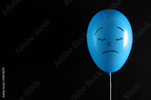 Photography Air balloon with drawn sad face on black background