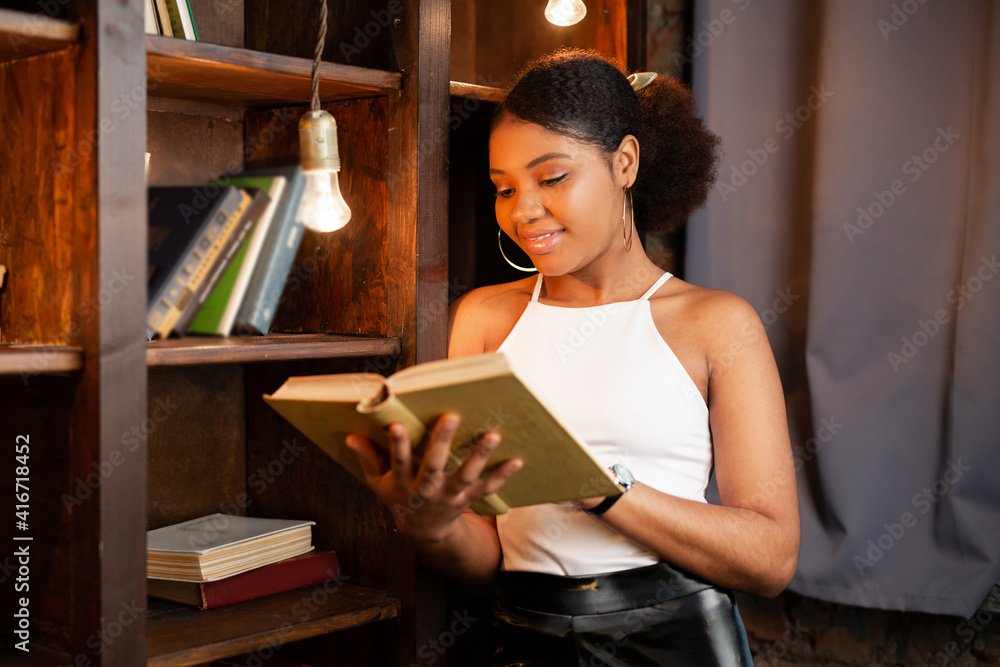 Naklejka premium beautiful young african woman reading a book 