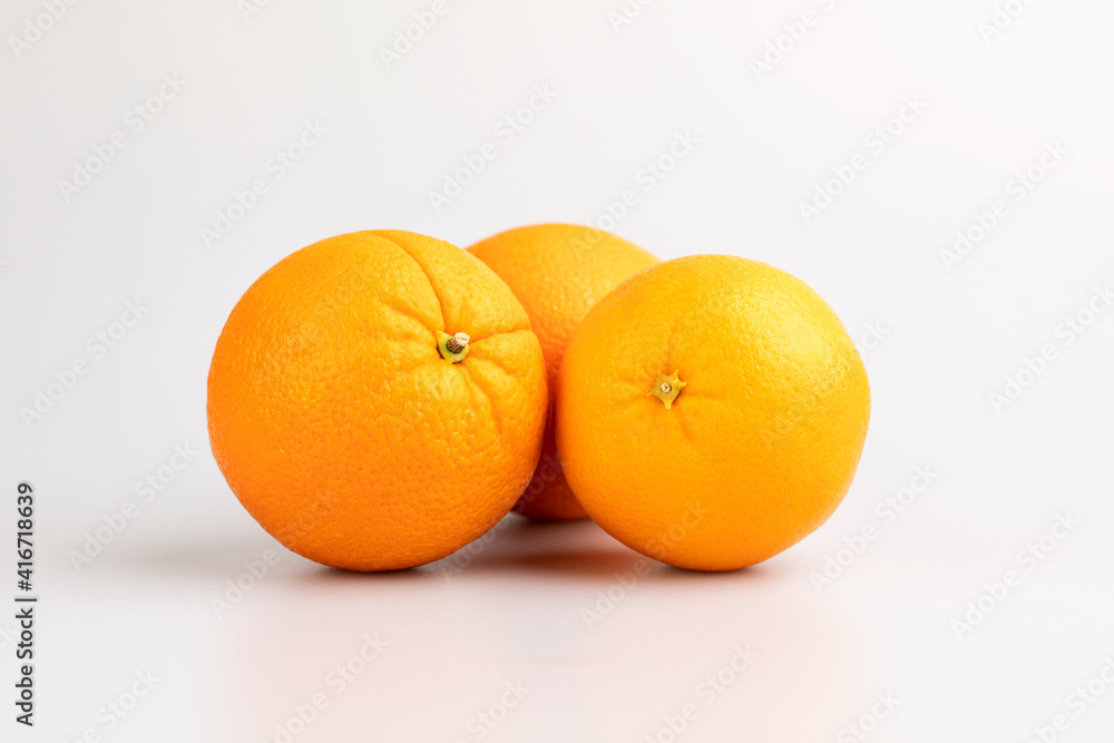 An orange in fruit with full and a half showing in isolated background. An orange in fruit with full and a half showing in isolated background.
