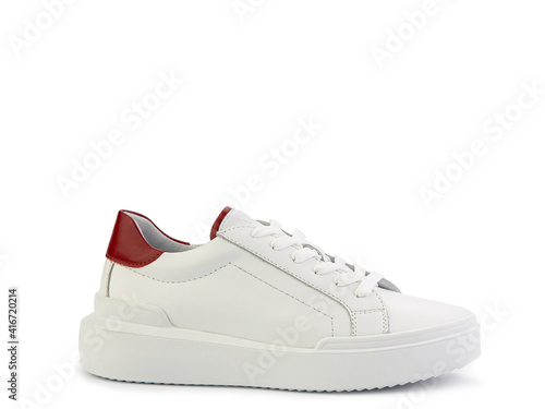 White leather sneakers with red pieces. Casual women's style. White lacing and white rubber soles. Isolated close-up on white background. Left side view. Fashion shoes.