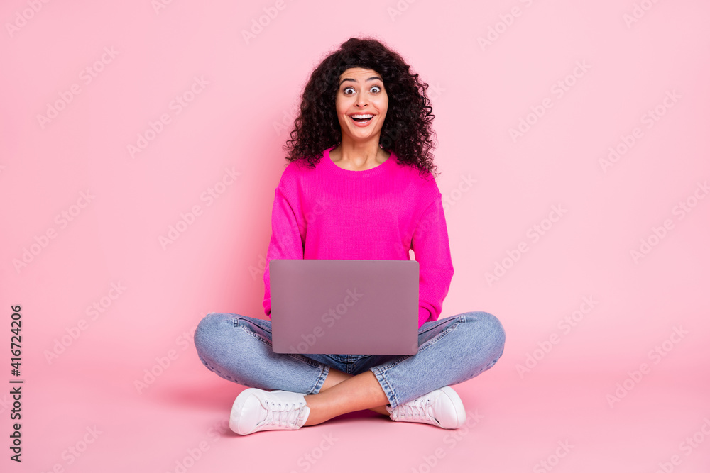 Full size photo of young happy excited shocked positive girl working in laptop sit floor isolated on pink color background Full size photo of young happy excited shocked positive girl working in laptop sit floor isolated on pink color background