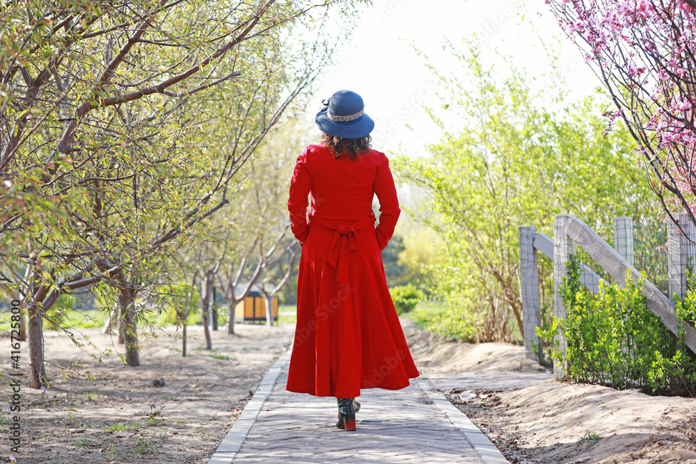 The lady is enjoying the flowers in the park. The lady is enjoying the flowers in the park.