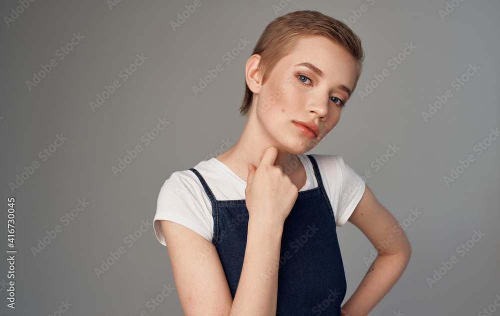 Woman with short hair Makeup on her face gray background Woman with short hair Makeup on her face gray background