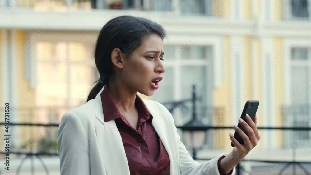 Disappointed female entrepreneur having video chat on mobile phone at street. Disappointed female entrepreneur having video chat on mobile phone at street.