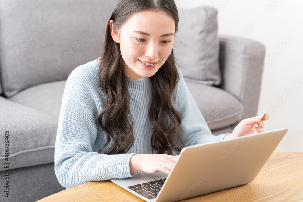 クレジットカードを使用する若いアジア人女性