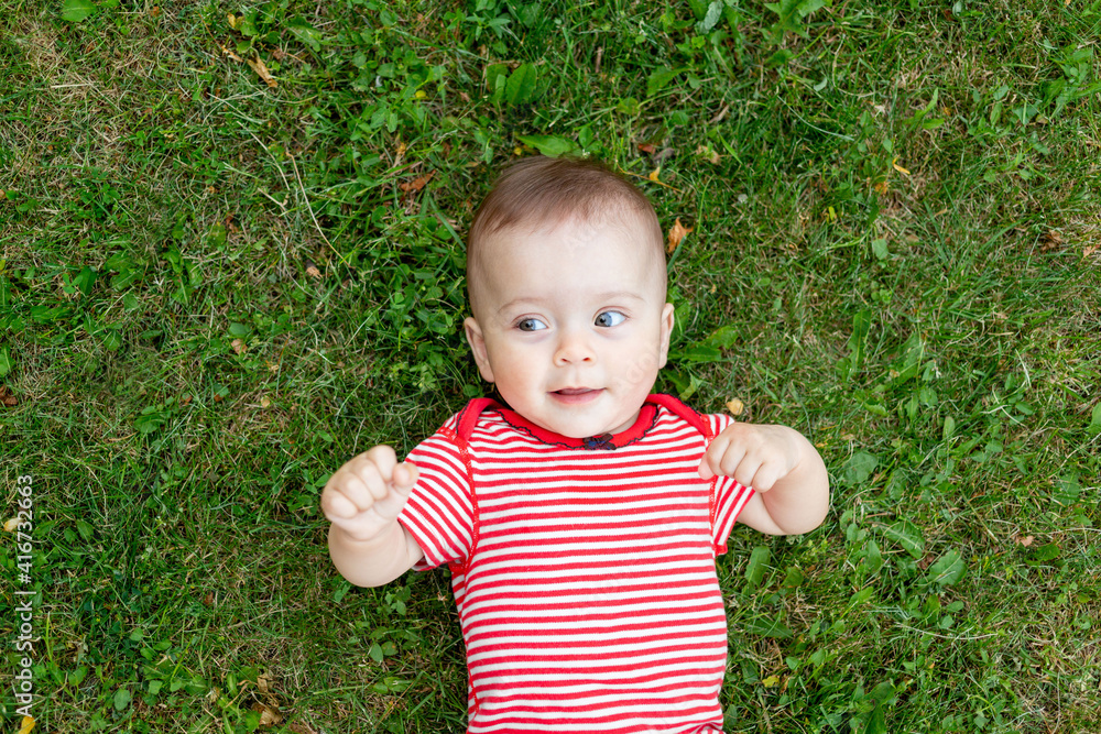 baby on the grass or green lawn, baby walking outside in the summer, place for text