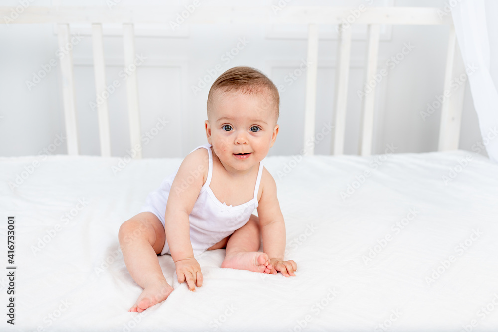 the baby is sitting in a crib in a bright room the baby is sitting in a crib in a bright room