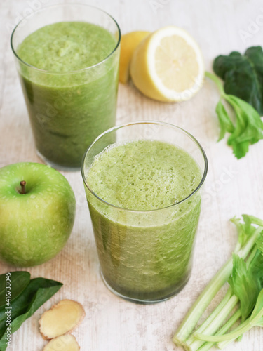 Glass of natural organic and healthy green vegetable juice such as celery, cucumber, spinach and apple. A plant base medical concept. Fresh green juice improve a digestive and many health benefits