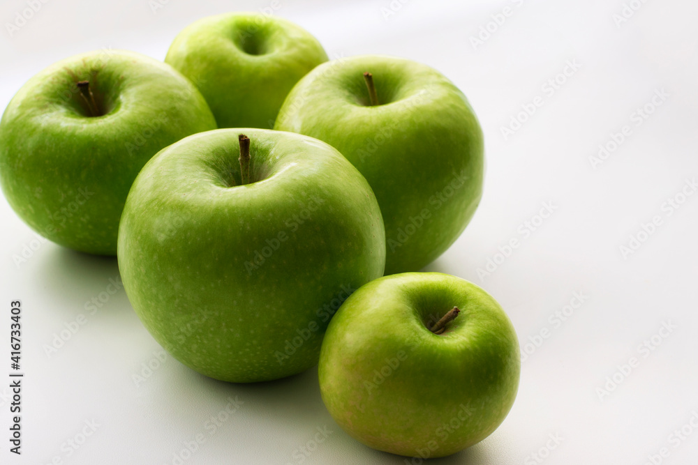 Ripe green apples on a white window. Juicy fruits on a white background. Ripe green apples on a white window. Juicy fruits on a white background.
