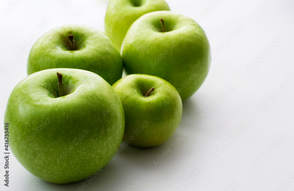 Ripe green apples on a white window. Juicy fruits on a white background. Ripe green apples on a white window. Juicy fruits on a white background.