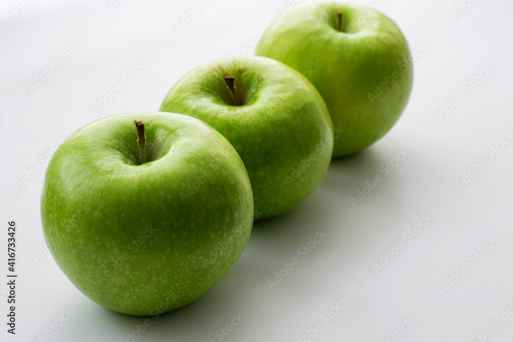 Ripe green apples on a white window. Juicy fruits on a white background. Ripe green apples on a white window. Juicy fruits on a white background.