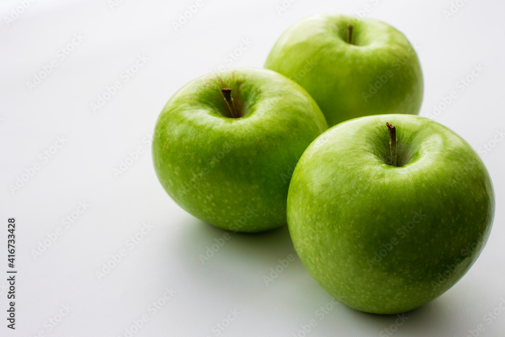 Ripe green apples on a white window. Juicy fruits on a white background. Ripe green apples on a white window. Juicy fruits on a white background.