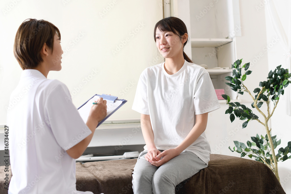 Fototapeta premium 整体（カイロプラクティック）のカウンセリング中の女性イメージ
