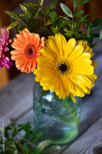 Pink, orange and yellow gerberas in a glass vintage vase.