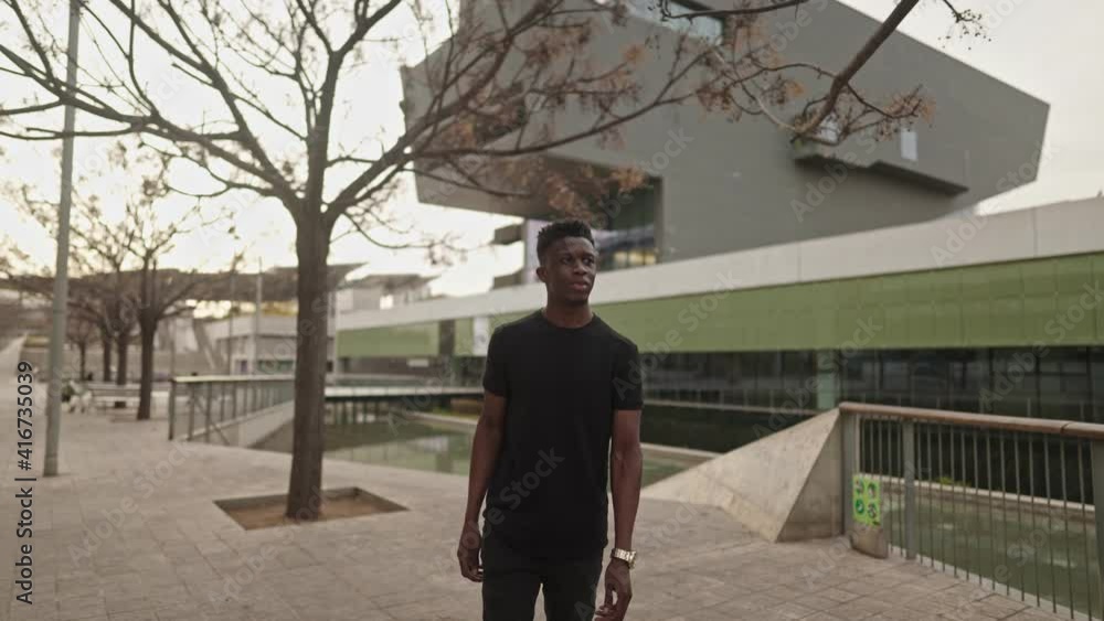 Stylish portrait of a cool black african american man in a downtown city center. Shot in 4k. City exploring Stylish portrait of a cool black african american man in a downtown city center. Shot in 4k. City exploring