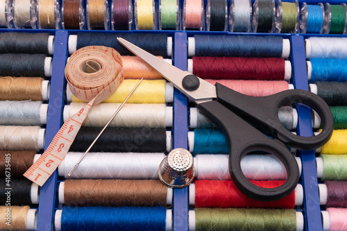 Fotografie image of different colored sewing threads and sewing tools