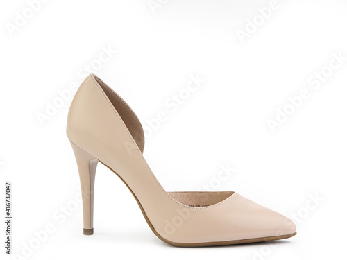Classic and elegant high-heeled women shoes. Minimalist and stylish beige shoes on high heels. Isolated object close up on white background. Right side view. Fashion shoes.