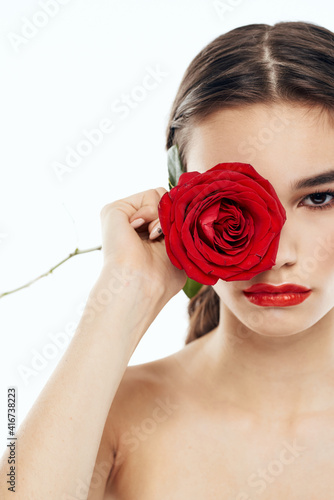Woman with red rose in hands and make-up eye shadow model naked shoulders cropped view
