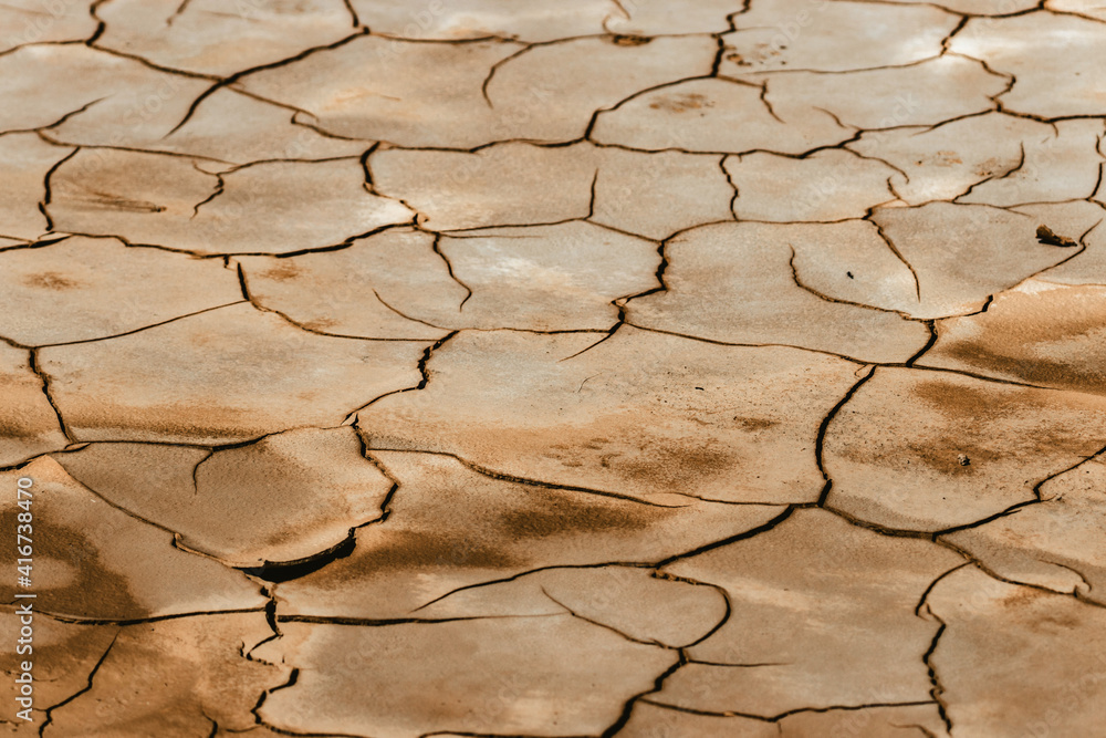 Tierra seca y agrietada cuarteada por el sol y la sequía