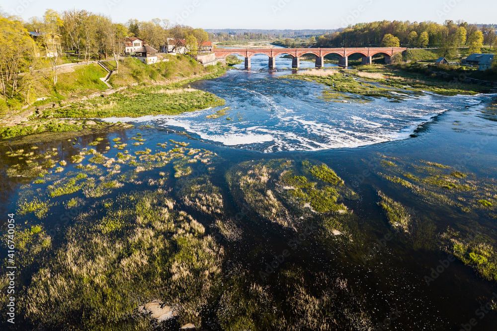 Venta Rapid waterfall, the widest waterfall in Europe and long brick bridge, Kuldiga, Latvia. Captured from above.