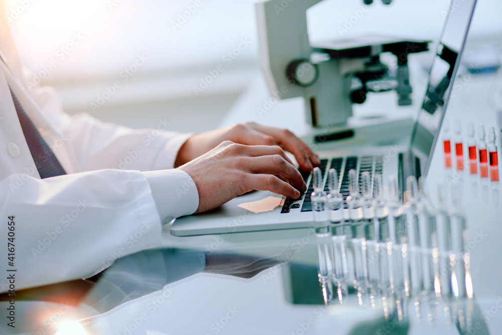 scientist works on a laptop in a medical laboratory.