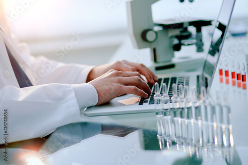 Obraz na płótnie scientist works on a laptop in a medical laboratory. w salonie