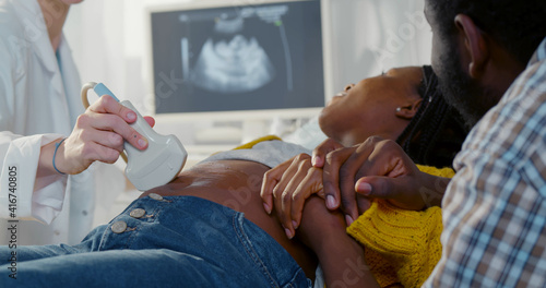 Wallpaper Mural Afro pregnant couple smiling looking at sonogram results on monitor while on checkup at gynecologist Torontodigital.ca
