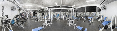 Panorama of a retro bright gym. White sport equipment and blue seats...