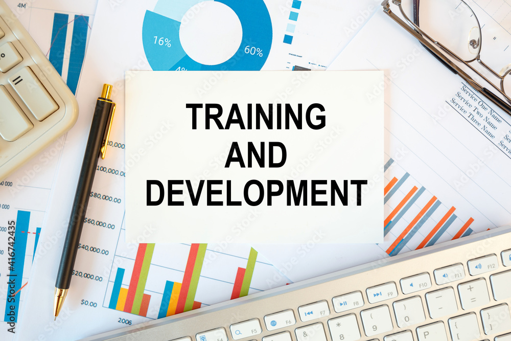 Training and Development is written in a document on the office desk, diagram and keyboard Training and Development is written in a document on the office desk, diagram and keyboard