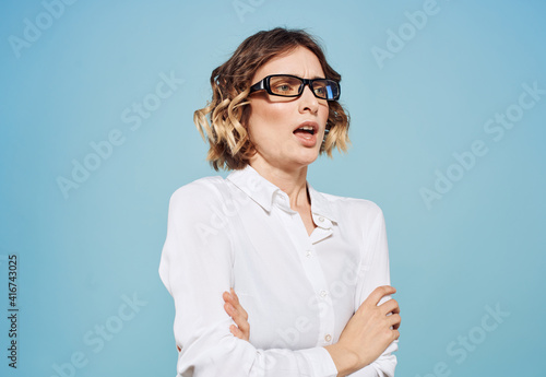 Emotional woman in white shirt puzzled look emotions gesturing with hands blue background