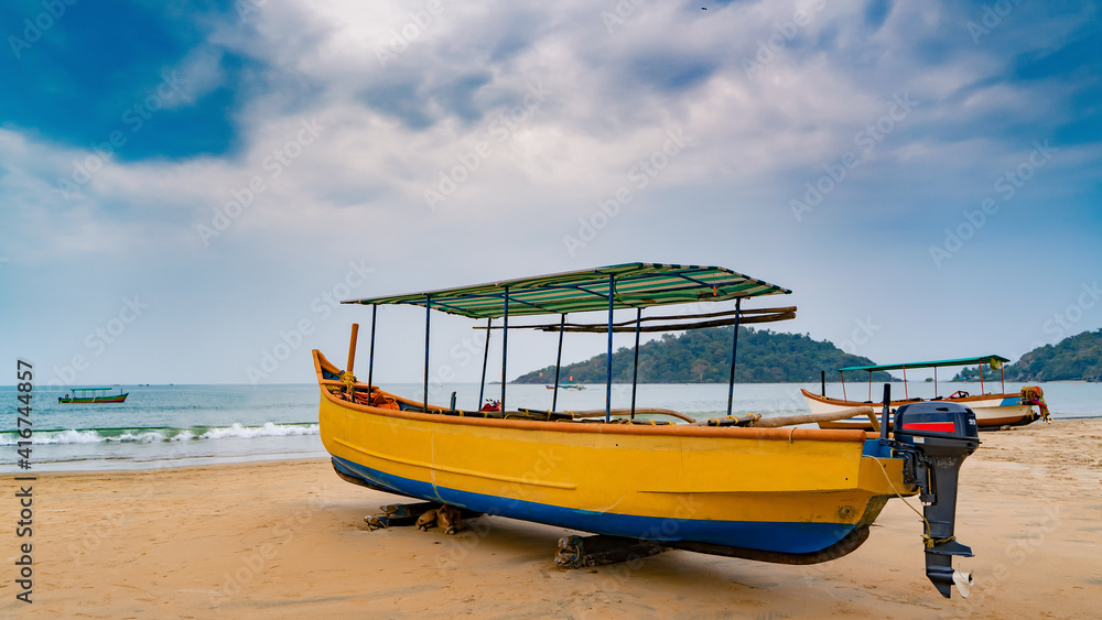 Fototapeta premium Yellow boat lying on the beach shore