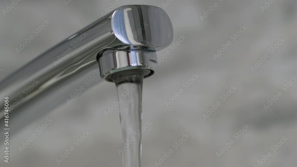 Flow of water pouring from chrome-plated faucet. Water flows from a faucet close-up. Running tap in Kitchen. 4K resolution Flow of water pouring from chrome-plated faucet. Water flows from a faucet close-up. Running tap in Kitchen. 4K resolution