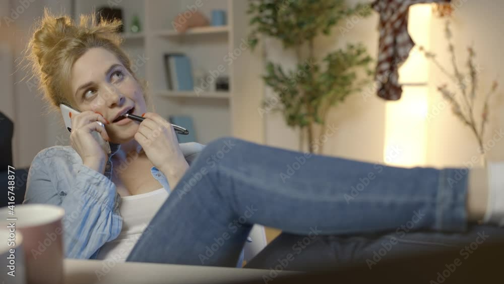 Young woman talking smartphone and laughing, putting legs on desk, laziness Young woman talking smartphone and laughing, putting legs on desk, laziness