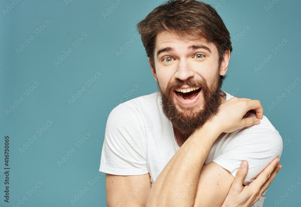 Obraz premium Close-up of a man gesturing with his hands on a blue background cropped view