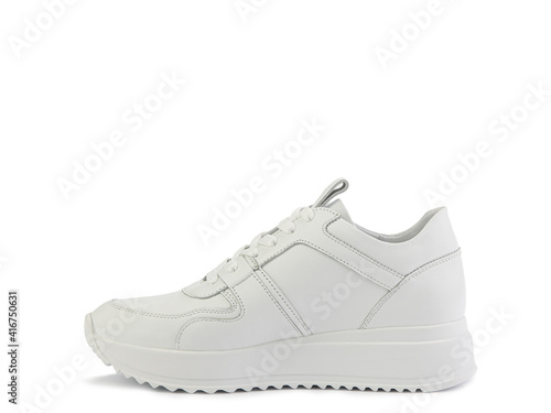 White classic leather trainers. Casual women's style. White lacing and white rubber soles. Isolated close-up on white background. Left side view. Fashion shoes.