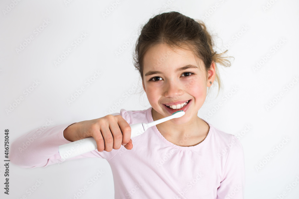 Child brushing their teeth with sonic electric tooth brush isolated on white background. Oral hygiene concept with copy space Child brushing their teeth with sonic electric tooth brush isolated on white background. Oral hygiene concept with copy space