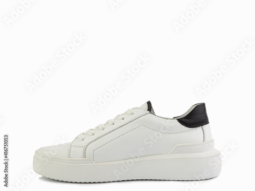 White leather sneakers with black details. Casual women's style. White lacing and white rubber soles. Isolated close-up on white background. Left side view. Fashion shoes.