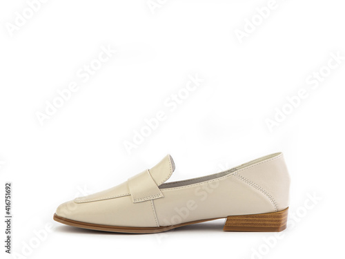 Stylish and elegant ivory women's loafers. Trendy flat leather shoes with square toe and beige sole. Isolated close-up on white background. Left side view. Fashion shoes.