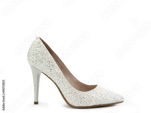 Elegant, glamorous and sparkly high-heeled women shoes. White shoes with silver glitters and a high silver heel. Isolated close-up on white background. Right side view. Fashion shoes.