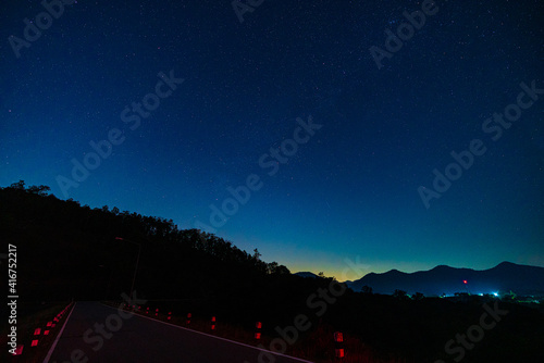The Milky Way galaxy and mountain, road with stars and space dust in the universe, Long exposure photography with grain